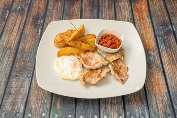 Plate of pork tenderloin with tomato and egg