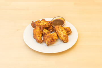 Serving of chicken wings on wooden table