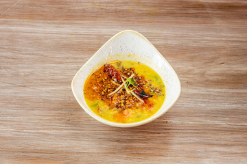Plate of Tadka wali dal on wooden background