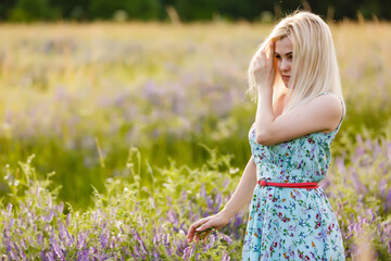 Fototapeta na wymiar outdoor portrait of a beautiful middle aged blonde woman. attractive sexy girl in a field with flowers