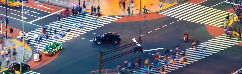 People and traffic cross the famous scramble intersection in Shibuya, Tokyo, Japan, one of the busiest crosswalks in the world