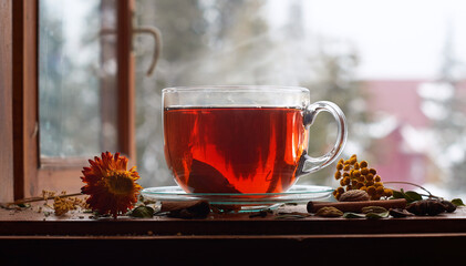 Tea cup with tea leaves on window. Tea time.