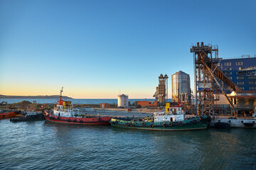 Ships in a cargo seaport at sunset.