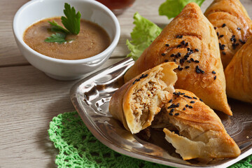 Plate with delicious  samsa with meat on gray background. Meat dish of the peoples of Central and Central Asia, dough, meat and onions, suitable for the Nauryz or Navruz holidays