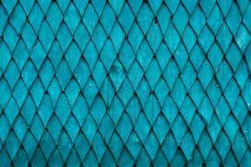 The wall of the house is made of old wood. Wooden details in the form of a rhombus. Background and texture of old painted wood..