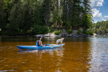 Femme en kayak avec un chien sur la rivière Rouge