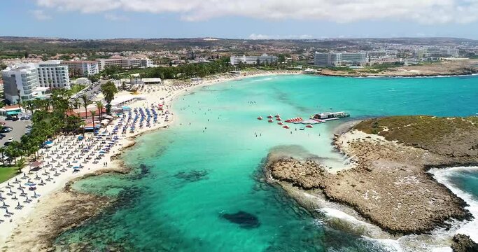 Aerial footage view of turquoise transparent crystal clean water of Nissi beach, Ayia Napa, Famagusta, Cyprus from above on a windy day.