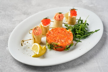  Thin rolled pancakes, crepes with salmon and red caviar, fish tartare.