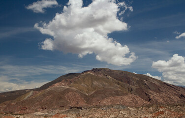 Desert landscape. Colorful hill under a beautiful single cloud.