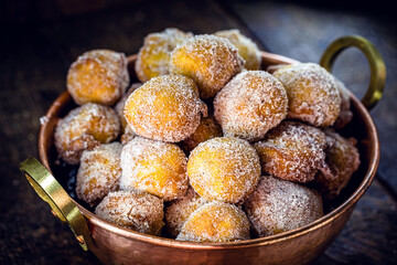 Brazilian sweet called Bolinho de Chuva, made with cinnamon, refined and fried sugar. Food served in a copper pot, typical sweet from minas gerais and são paulo.