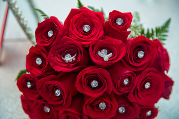 Set of wedding rings in Red rose taken closeup . Bride and groom rings on a red wedding bouquet. A bouquet of roses for a wedding. wedding rings on red roses .