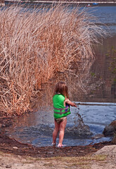 This cute 3 year old Caucasian girl is having great childhood fun  playing in the mud with a mighty...