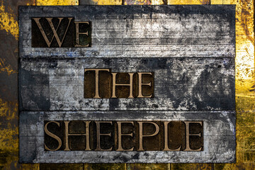 We The Sheeple text formed with real authentic typeset letters on vintage textured silver grunge copper and gold background