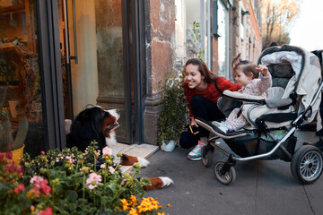 mother and daughter on the street looking at the dog
