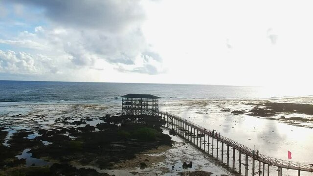 Slow drone shot of a tower used for viewing surfers do their thing in the famous Cloud9 beach in Siargao