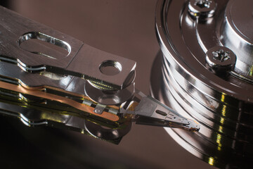  Macro photo of magnetic head, mirrored magnetic disk and spindle. Part of detail view of internal structure of HDD.