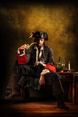 Fototapeta na wymiar Portrait of a pirate smoking a pipe, sitting in a tavern