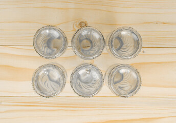 Empty glass bottles lined up in opposite ways on light brown background. Top of glass bottles with copy and writing space.
