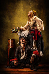 Portrait of a couple of pirates drinking rum in a tavern