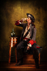 Portrait of a pirate drinking rum, sitting in a tavern - obrazy, fototapety, plakaty