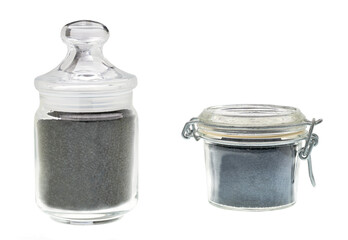 Glass jar with black cumin isolated on a white background.