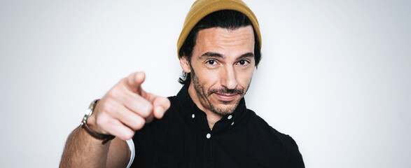Portrait of a handsome guy pointing his finger at camera