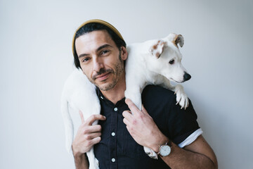 Studio portrait of a handsome guy holding his dog