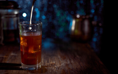 Dark brown coffee in a glass in which a drop of milk falls. With copy space