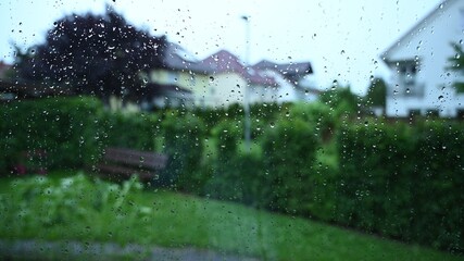 it rains heavily in a front garden in germany, storms are frequent due to climate change