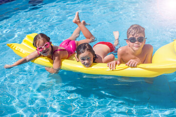 Kids playing in the swimming pool. Childhood, summer and vacation concept