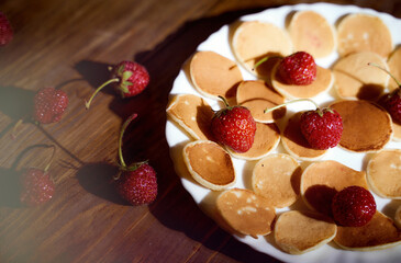 Ripe strawberries lie on a white plate. dark wooden table. With copy space. Top view