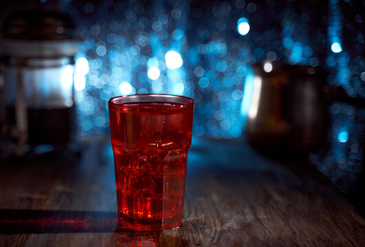 Red cocktail glass on krast paper. Blue blurred background. With copy space