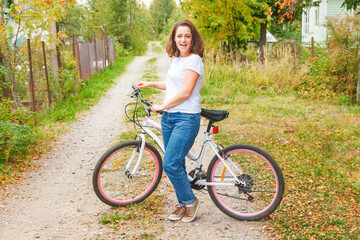 Obraz premium Young woman riding bicycle in summer city park outdoors. Active people. Hipster girl relax and rider bike. Cycling to work at summer day. Bicycle and ecology lifestyle concept.