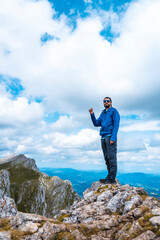 Obraz premium Mount Aizkorri 1523 meters, the highest in Guipúzcoa. Basque Country. Ascent through San Adrián and return through the Oltza fields. A young man in blue looking at the views from the top