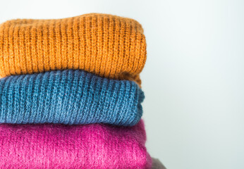 Pile of colorful woolen sweaters. Fall, winter fashion colors