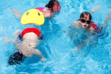 Kids playing in the swimming pool. Childhood, summer and vacation concept