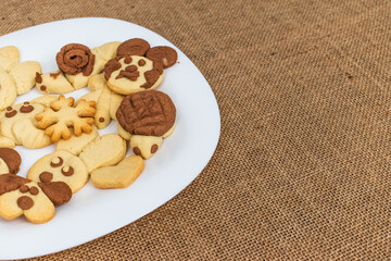 homemade cookies in the shape of dog, heart, elephant, butterfly, snowflake, slug, turtle, heart, rabbit, chamomile and owl in the tray. animal shaped cookies made for children.