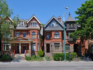 Fototapeta na wymiar Street with row of old brick houses with gables