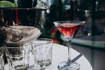 a glass filled with red wine stands on a table next to other glasses on a table with a white tablecloth