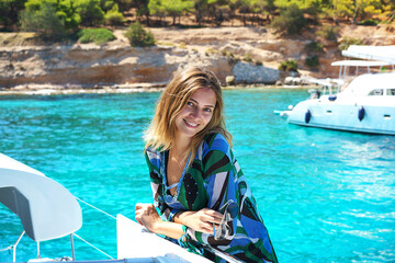 Young happy woman in sunglasses feels fun on the luxury sail boat yacht catamaran in turquoise sea...
