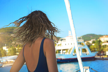 Young happy woman in sunglasses feels fun on the luxury sail boat yacht catamaran in turquoise sea...