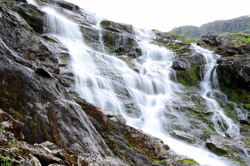 Fototapeta na wymiar clean fresh water stream running down mountain side in summer landscape