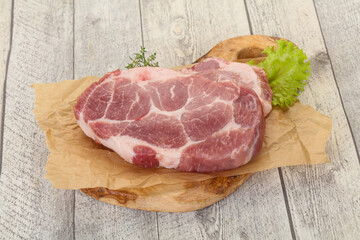 Raw pork steak over wooden board