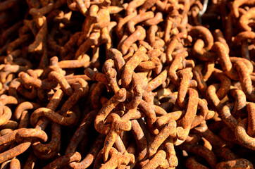 beautiful old rusted chains in a pile in summer sunlight