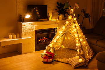 Christmas with gifts near a wigwam and a fireplace © Angelov
