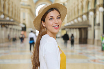 Close up of smiling fashion tourist woman visiting Vittorio Emanuele Gallery in the city of Milan, Italy