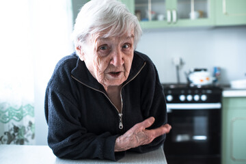 An elderly old woman portrait near window in the her house.