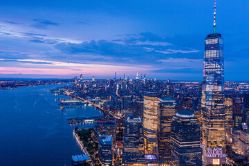 Aerial view of New York City skyline at sunset with both midtown, WTC, and downtown Manhattan