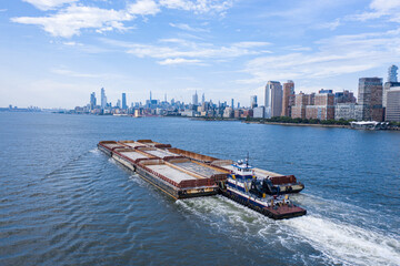 Fototapeta na wymiar Barging ship with manhattan skyline from Hudson river 