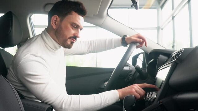 Stylish man in a new Renault use the sensor at a prestigious auto show. Auto business, car sale
